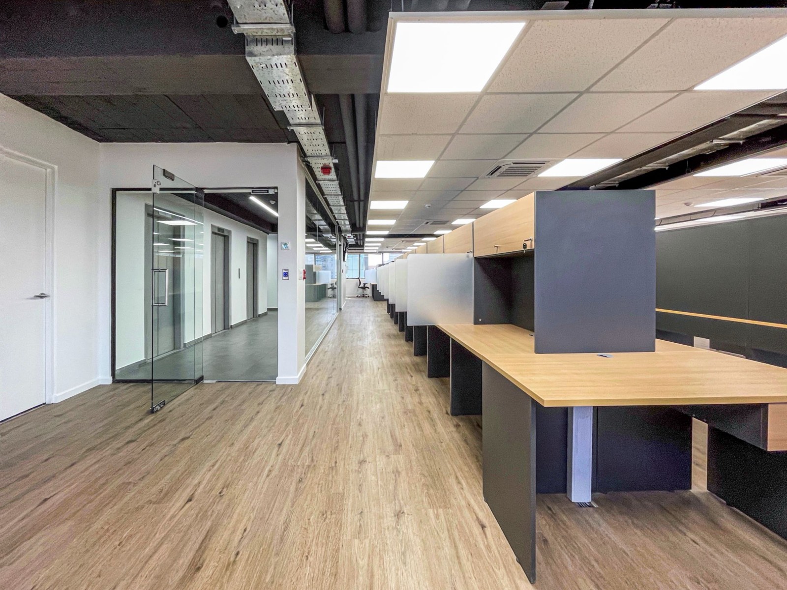Planta libre del call center Policomp con puestos de trabajo en hilera y cielo a la vista